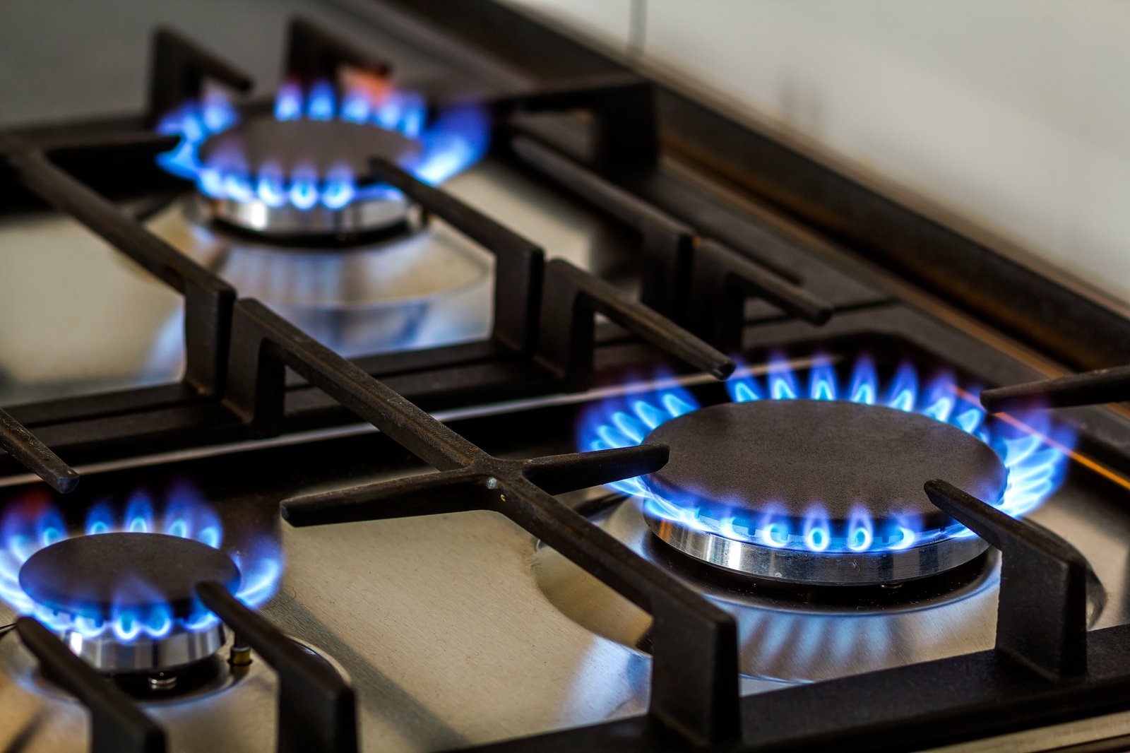 natural gas burning on kitchen gas stove in the dark panel from steel with a gas ring burner on a