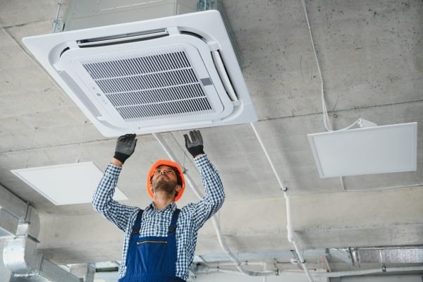 specialist cleans and repairs the wall air conditioner
