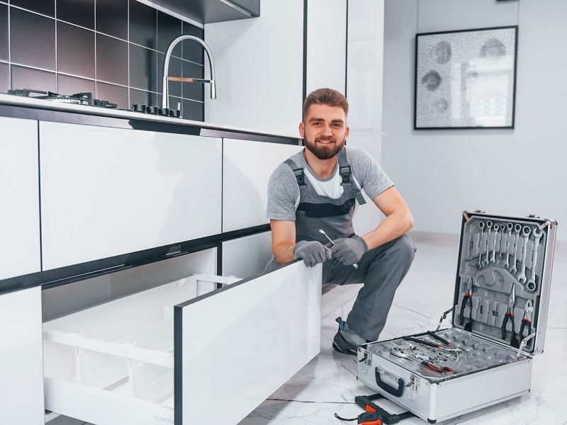 young professional plumber in grey uniform using e resize